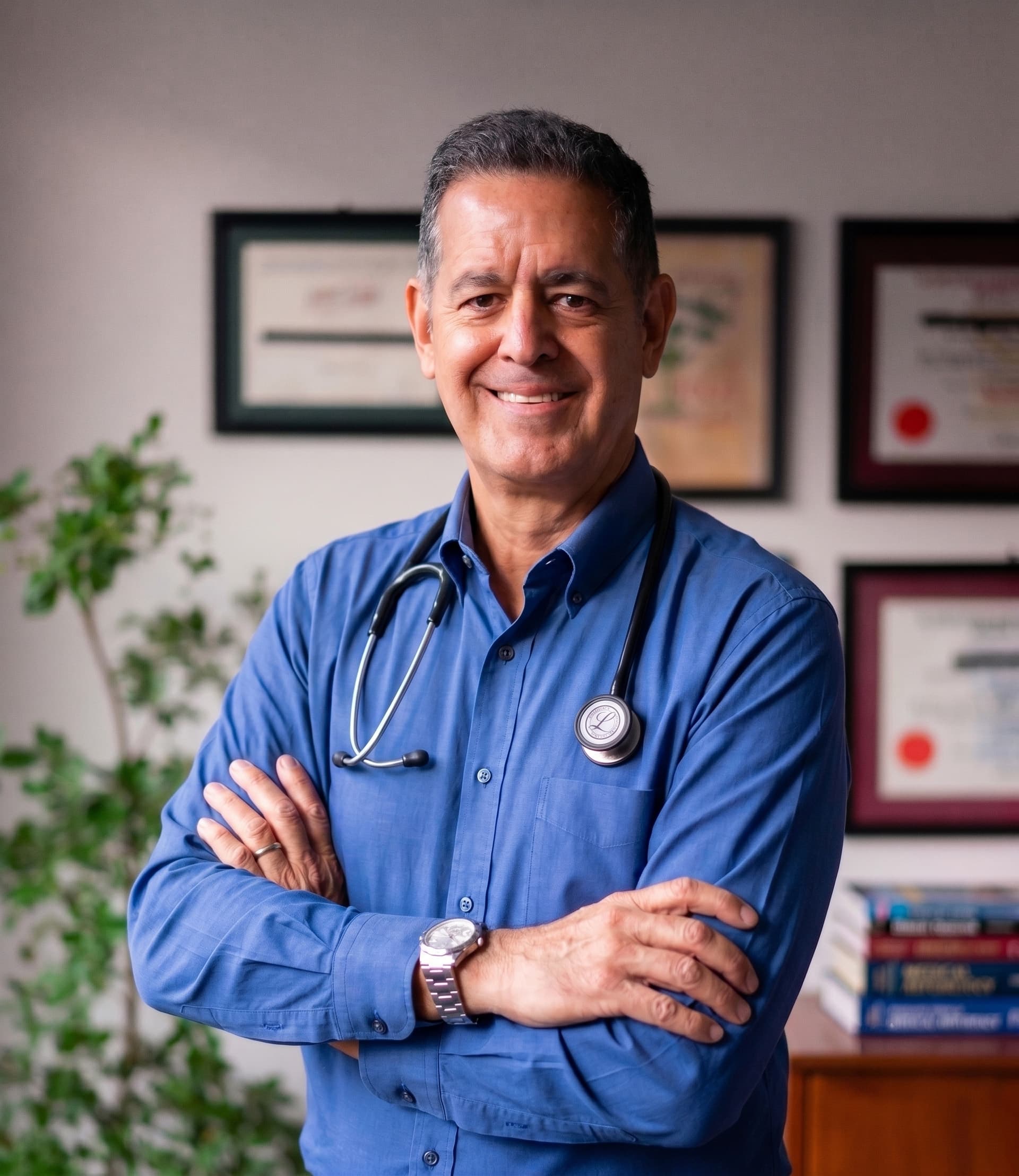 Smiling doctor standing with arms crossed in an office